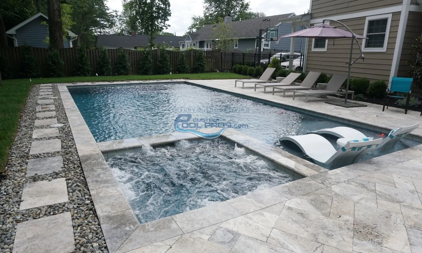 inground pool with spa and sun tanning ledge with chaise lounge chairs