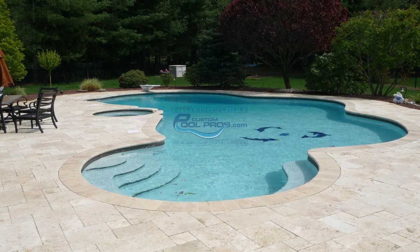 inground freeform pool with travertine pool patio deck backyard