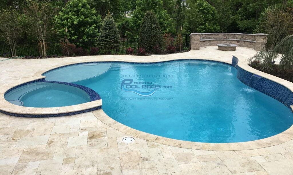 freeform inground gunite concrete pool with spa with vanishing edge, fire pit sitting area with concrete bench, swimming pool contractor.