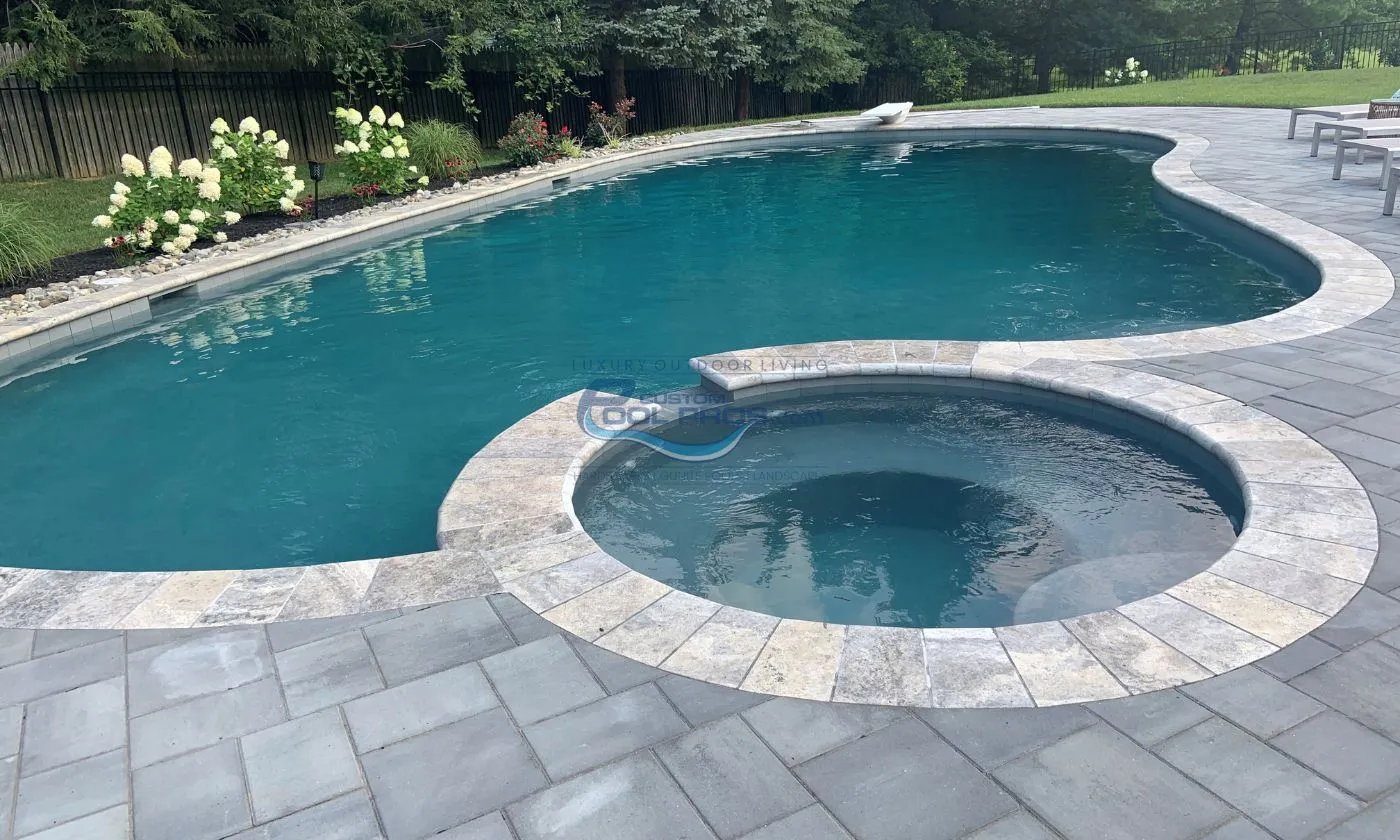 freeform inground pool installation with round spa, bull nose coping, pool deck