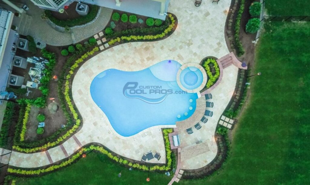 aerial view of luxury inground pool with swim up bar, travertine pool patio deck