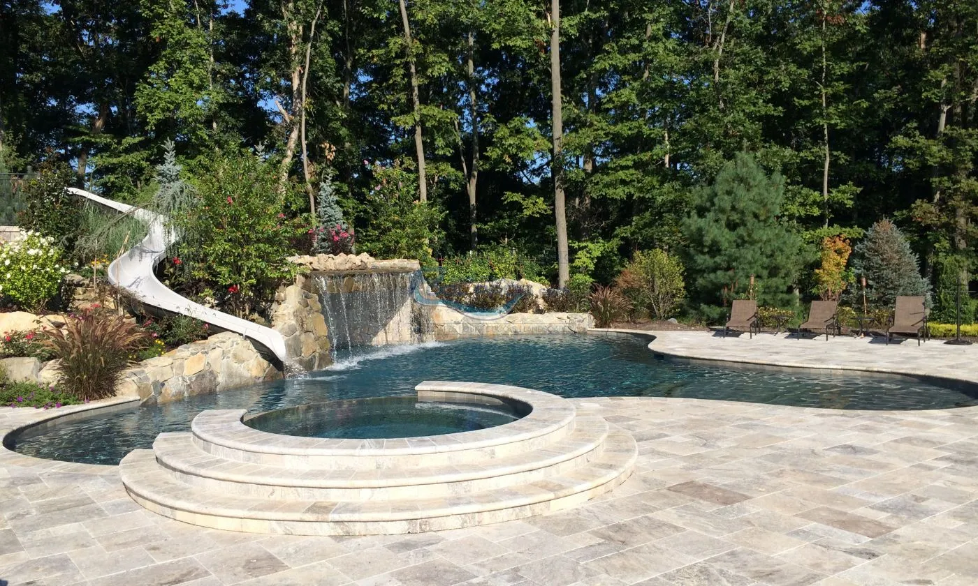 freeform inground gunite pool with grotto waterfall,slide and pool patio backyard, inground pool